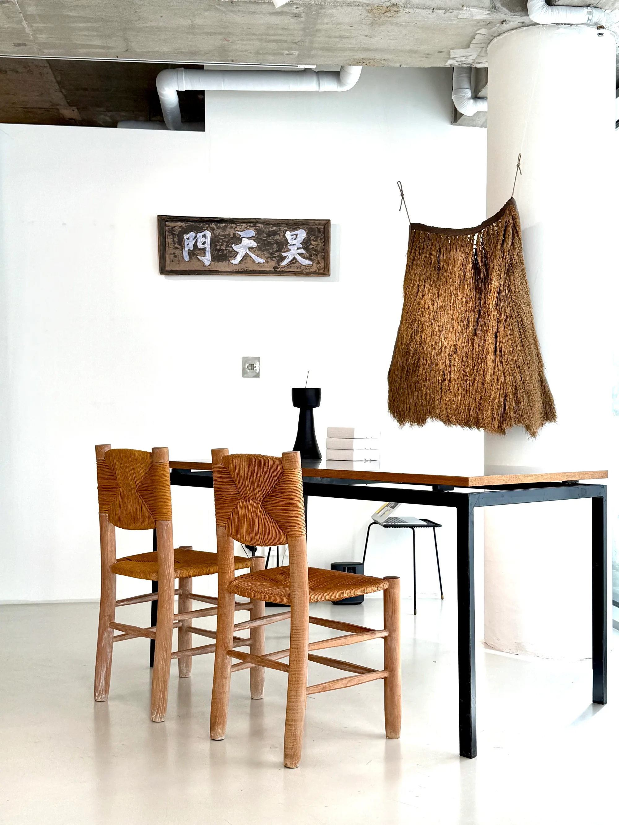 Summer 2025 ‘Hyeongsim’ exhibition at Le Modular — the dorongi on the wall beside a signboard and rush chairs
